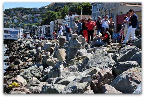 Visitors watch a local artist balance rocks in Sausalito.